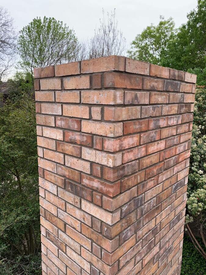 Brick chimney rebuilt from the roofline up