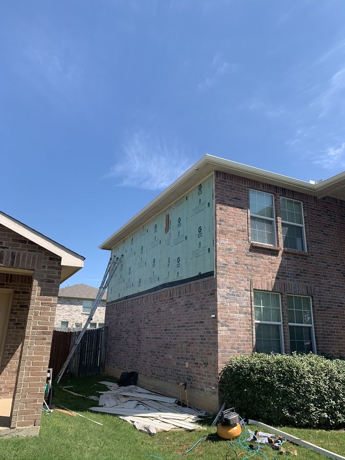 Upper-storey siding replaced over brick in Denton — Before — stripped back to house wrap