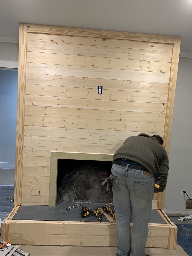 Pine shiplap going up on a fireplace surround