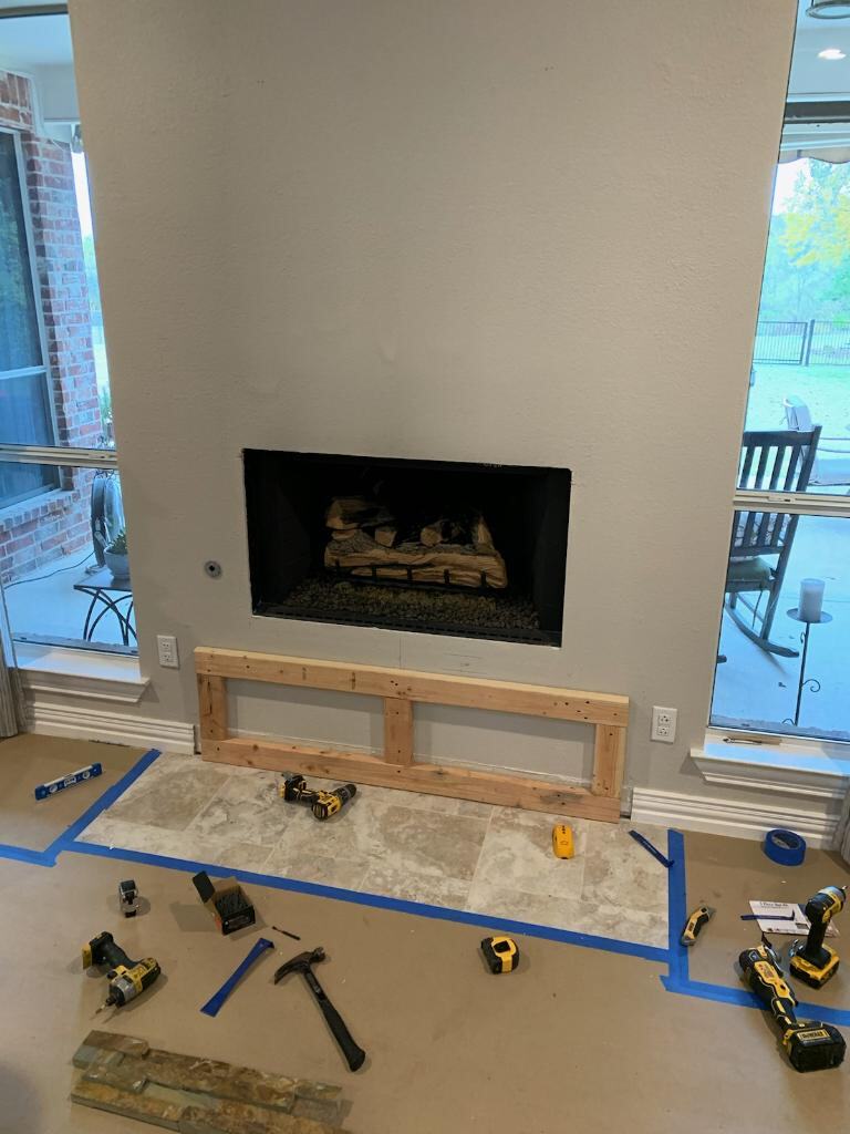 Before: plain drywall fireplace with hearth framing started
