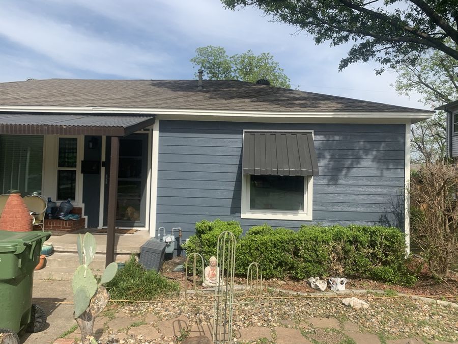 Single-story home in Downtown Garland after a full re-side in navy lap siding with white trim