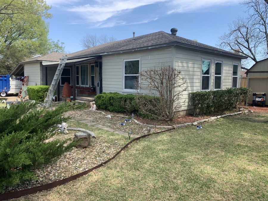 The same Garland home before, with failing painted wood siding