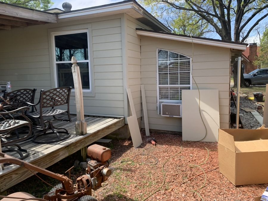 Whole-house re-side, cream to navy in Downtown Garland — During — new siding going up