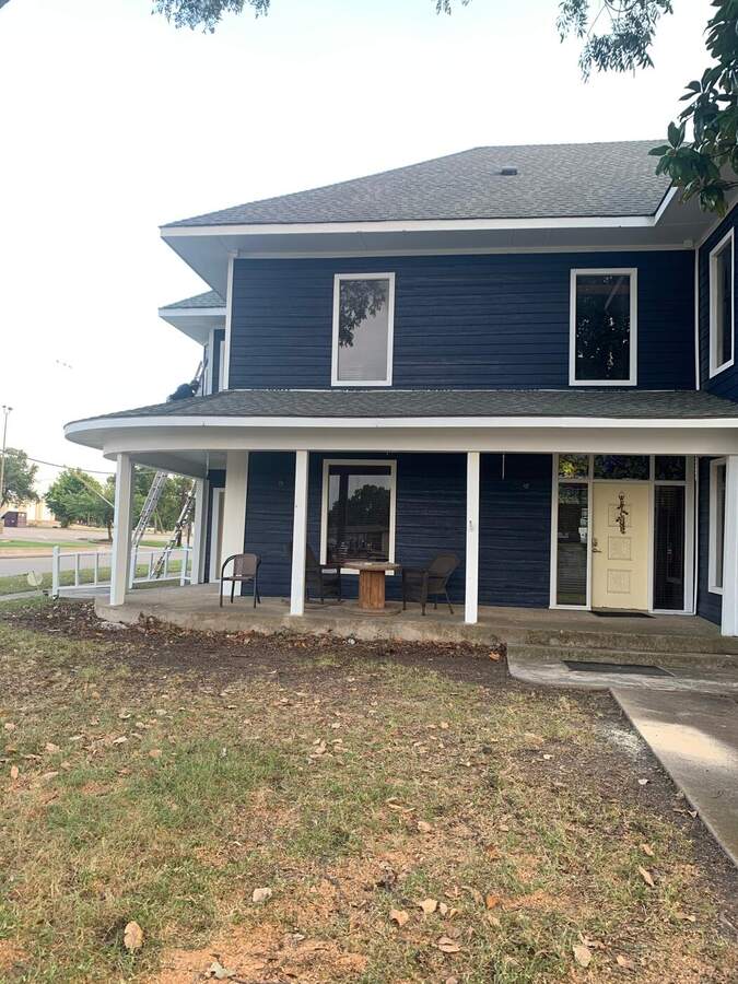 Two-story home with new navy siding and white trim installed by Top Flight