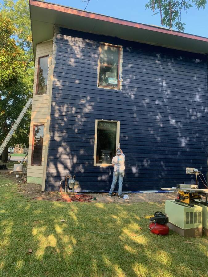 Crew installing new siding on a two-story home