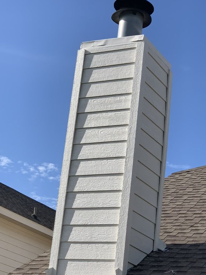 Chimney chase re-sided in white lap siding with a new cap in Southlake