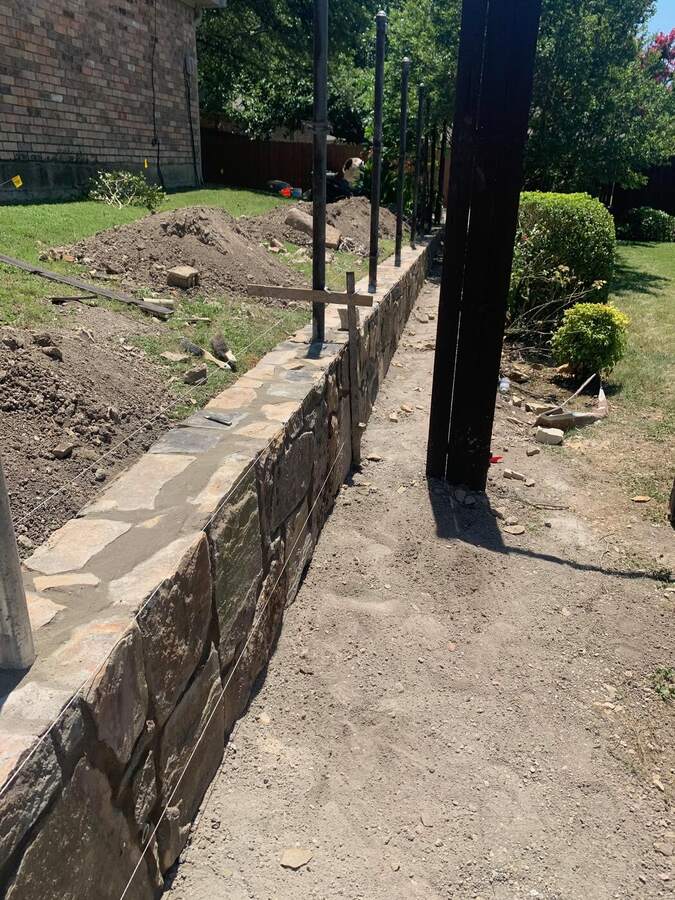 Finished stone retaining wall with new steel posts